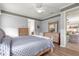 Well-lit bedroom featuring wood floors, ceiling fan, and comfortable bed with gray quilt at 9925 Sw 95Th Loop, Ocala, FL 34481