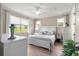 Light, airy bedroom with hardwood floors, white furniture, and green outdoor view at 9925 Sw 95Th Loop, Ocala, FL 34481
