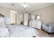 Cozy bedroom featuring wood floors, white furniture, and sitting chair near window at 9925 Sw 95Th Loop, Ocala, FL 34481