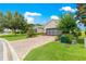 Long brick driveway leads to a well-kept house with manicured landscaping at 9925 Sw 95Th Loop, Ocala, FL 34481