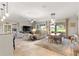 Bright living area featuring tile floors, modern lighting, and open access to a dining area and view of the backyard at 9925 Sw 95Th Loop, Ocala, FL 34481