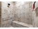 Tiled walk-in shower with neutral tones, bench, and a shower head at 9925 Sw 95Th Loop, Ocala, FL 34481