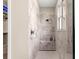 Walk-in shower with tiled walls, a shower bench, and a window for natural light at 9925 Sw 95Th Loop, Ocala, FL 34481