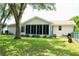 Well-maintained backyard featuring a screened-in porch and lush greenery at 8896 Sw 116Th Place Rd, Ocala, FL 34481