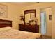 Comfortable main bedroom features a decorative wooden dresser and a glimpse into an en-suite bathroom at 8896 Sw 116Th Place Rd, Ocala, FL 34481