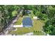 Drone view of the property, showing the home, driveway, and surrounding mature trees at 1133 Nw 122Nd Pl, Citra, FL 32113