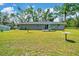 Expansive backyard showing the home's exterior with a small deck and large grassy area at 1133 Nw 122Nd Pl, Citra, FL 32113
