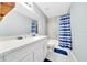 Updated bathroom features a new vanity, quartz countertop, and a shower with blue and white striped curtain at 1133 Nw 122Nd Pl, Citra, FL 32113
