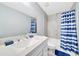 Bathroom features a new vanity, quartz countertop, and a shower with blue and white striped curtain at 1133 Nw 122Nd Pl, Citra, FL 32113