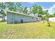 Rear exterior view showcasing the home's siding, AC unit and sliding glass door to backyard at 1133 Nw 122Nd Pl, Citra, FL 32113