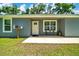 Close-up of the home's entrance featuring a charming porch and manicured lawn at 1133 Nw 122Nd Pl, Citra, FL 32113