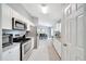 Open kitchen view with stainless steel appliances, white cabinetry, and dining area at 1133 Nw 122Nd Pl, Citra, FL 32113