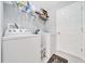 Bright laundry room with washer, dryer, storage shelves, and white door to exterior at 1133 Nw 122Nd Pl, Citra, FL 32113