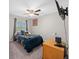 Comfortable bedroom featuring neutral walls, ceiling fan, and a mounted TV at 11330 Sw 61St Cir, Ocala, FL 34476