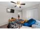 Bedroom with a ceiling fan, TV, closet, and a glimpse into the living room at 11330 Sw 61St Cir, Ocala, FL 34476