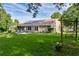Well-manicured lawn, back of home featuring solar panels, and swing set with lush surrounding greenery at 11598 Sw 74Th Ct, Ocala, FL 34476