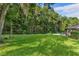 Sprawling backyard with a stone patio, swing, and bordered by mature trees for added privacy at 11598 Sw 74Th Ct, Ocala, FL 34476