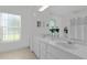 Bright bathroom featuring double vanity with framed mirrors and a window that provides ample natural light at 11598 Sw 74Th Ct, Ocala, FL 34476