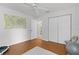 Clean bedroom with hardwood floors, ceiling fan, and large closet, next to an adjacent doorway at 11598 Sw 74Th Ct, Ocala, FL 34476