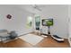 Minimalist bedroom space with natural light, hardwood floors, ceiling fan, and a wall-mounted television at 11598 Sw 74Th Ct, Ocala, FL 34476