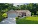 Charming single-story home with a well-maintained lawn, lush landscaping, and an attached two-car garage at 11598 Sw 74Th Ct, Ocala, FL 34476