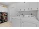 Practical laundry room with a white washer and dryer and plenty of cabinet space for storage at 11598 Sw 74Th Ct, Ocala, FL 34476
