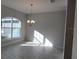 Sunlit dining room featuring a chandelier, large window, and neutral color palette at 12384 Sw 96Th Ln, Dunnellon, FL 34432