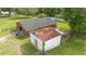 Aerial view showcases barn with white structure, bordered by green pastures and fencing at 1501 Ne 97Th Street Rd, Anthony, FL 32617