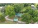 Aerial view of a home with a green roof surrounded by lush trees and a detached structure at 1501 Ne 97Th Street Rd, Anthony, FL 32617