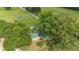 Aerial view of a home nestled among trees with a green roof and adjacent covered parking at 1501 Ne 97Th Street Rd, Anthony, FL 32617