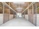 Spacious barn interior with multiple stalls, metal gates, and ample natural light streaming through at 1501 Ne 97Th Street Rd, Anthony, FL 32617