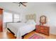 Cozy bedroom featuring white bedding, natural light, and charming vintage wooden furniture at 1501 Ne 97Th Street Rd, Anthony, FL 32617