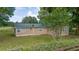 Ranch-style home with a green metal roof, tan siding, and well-maintained lawn on a fenced lot at 1501 Ne 97Th Street Rd, Anthony, FL 32617