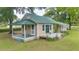 Charming home featuring a metal roof, a covered front porch and a wooden deck surrounded by a spacious green lawn at 1501 Ne 97Th Street Rd, Anthony, FL 32617