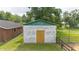 Exterior view of concrete block shed with wood door and green trim at 1501 Ne 97Th Street Rd, Anthony, FL 32617