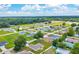 Aerial view of a community showcasing single-Gathering homes, green lawns, and a backdrop of lush trees at 1689 Ne 161St Pl, Citra, FL 32113