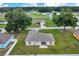 Aerial view of a home with a well-manicured lawn, surrounded by mature trees and neighboring houses at 1689 Ne 161St Pl, Citra, FL 32113