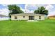 A spacious backyard with a large grassy area and a yellow house with black trim at 1689 Ne 161St Pl, Citra, FL 32113