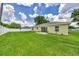 Spacious backyard featuring a lush lawn, white fence, and a home with a sliding glass door and windows at 1689 Ne 161St Pl, Citra, FL 32113