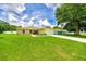 Well-maintained home featuring a wide green lawn, long driveway, and an attached two-car garage at 1689 Ne 161St Pl, Citra, FL 32113