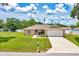 Attractive single-story home with a lush green lawn, sidewalk, and two-car garage on a sunny day at 1689 Ne 161St Pl, Citra, FL 32113
