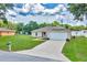 Charming home with a spacious lawn, long driveway, and attached two-car garage at 1689 Ne 161St Pl, Citra, FL 32113