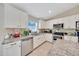 Modern kitchen featuring stainless steel appliances, granite countertops, white cabinetry, and tile flooring at 1689 Ne 161St Pl, Citra, FL 32113