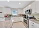 Modern kitchen with stainless steel appliances, granite countertops, white cabinets, and tile floors at 1689 Ne 161St Pl, Citra, FL 32113