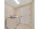 Bright laundry room featuring a white washer and dryer, ceramic tile floor, and a white door at 1689 Ne 161St Pl, Citra, FL 32113