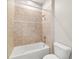 Tiled shower-tub combination with tan ceramic tiling and white fixtures at 2127 Ne 38Th Ter, Ocala, FL 34470
