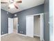 Bedroom with neutral carpet, blue walls, ceiling fan and bi-fold closet doors at 2127 Ne 38Th Ter, Ocala, FL 34470