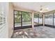 Enclosed patio featuring slate-look tile flooring, screened windows and ceiling fan at 2127 Ne 38Th Ter, Ocala, FL 34470