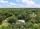 Aerial view of property surrounded by lush green trees and blue skies at 2155 Nw 27Th Ave, Ocala, FL 34475