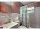 Bathroom with striped wallpaper, white sink and shower-tub combination with striped curtain, window and mirror at 2155 Nw 27Th Ave, Ocala, FL 34475